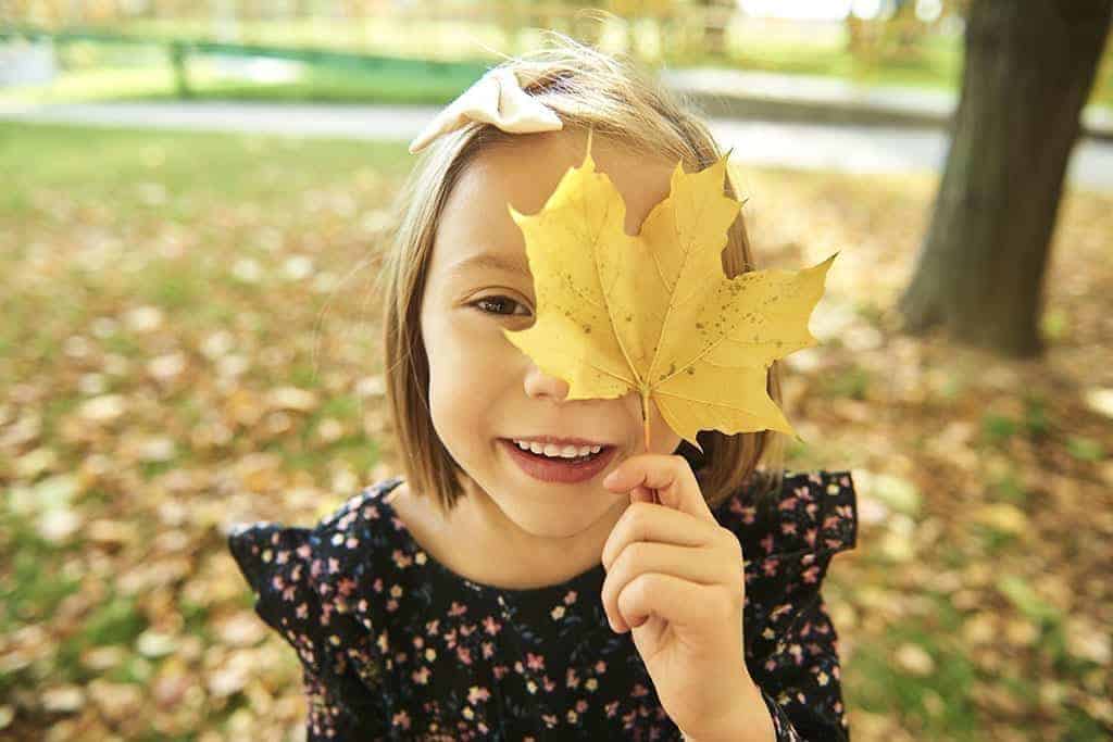 devojcica se igra sa jesenjim listicem i kao dete izrazava emocije